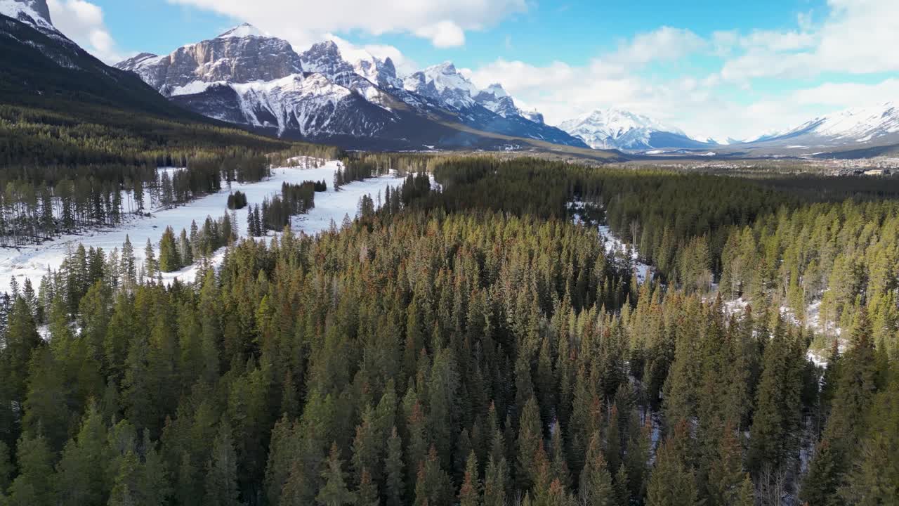 foto aérea de una zona boscosa con montañas en el fondo, canmore, alberta, canadá