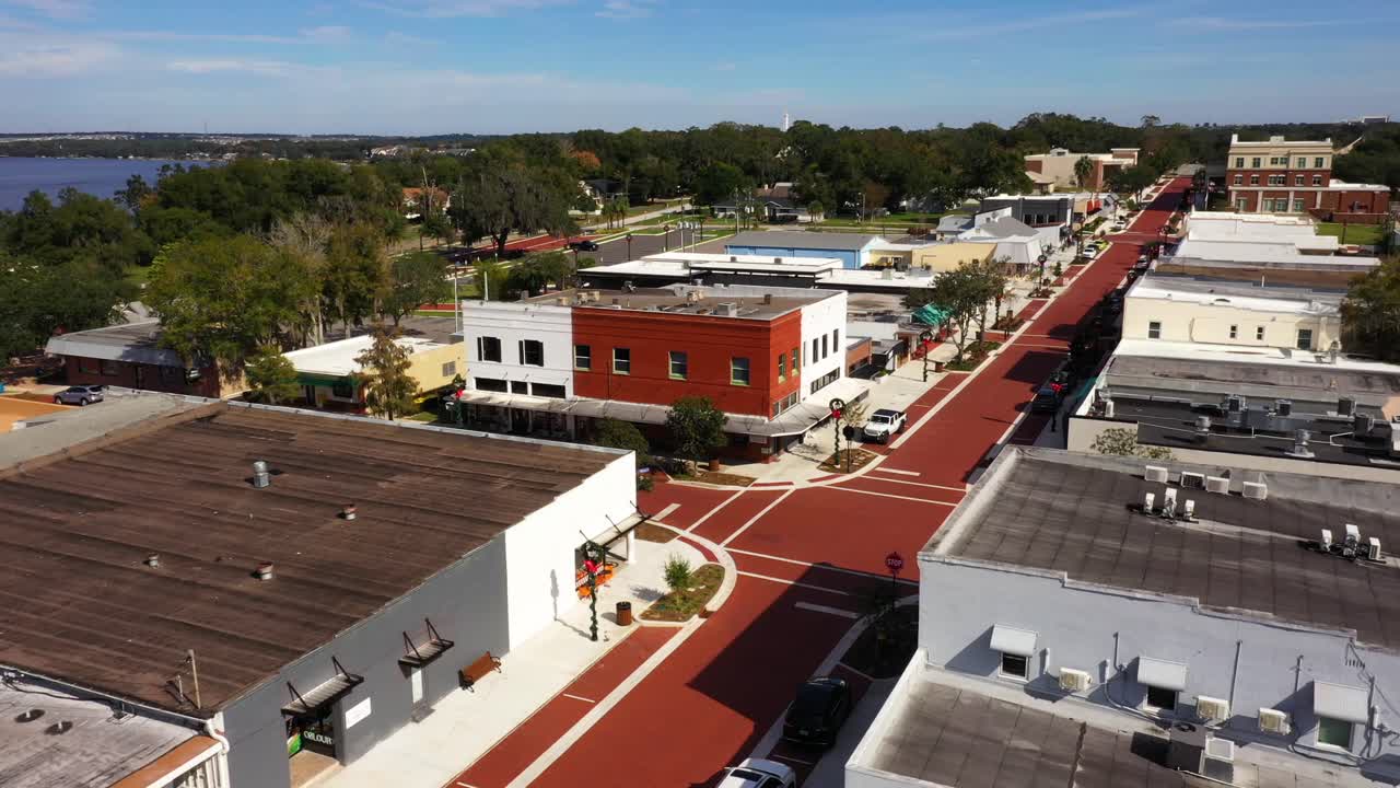 el dron orbita alrededor de un edificio de ladrillo rojo y blanco en la intersección de la esquina de clermont, florida.