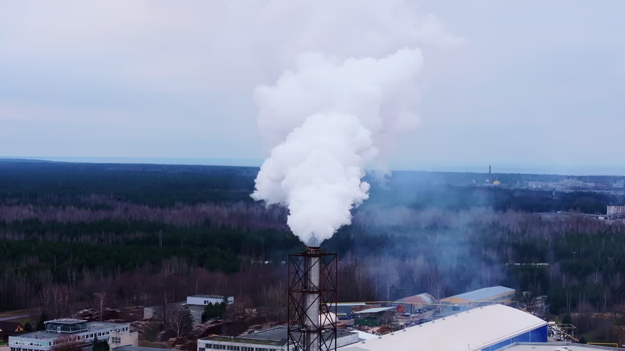 A factory chimney releases thick toxic smoke, polluting air and harming climate