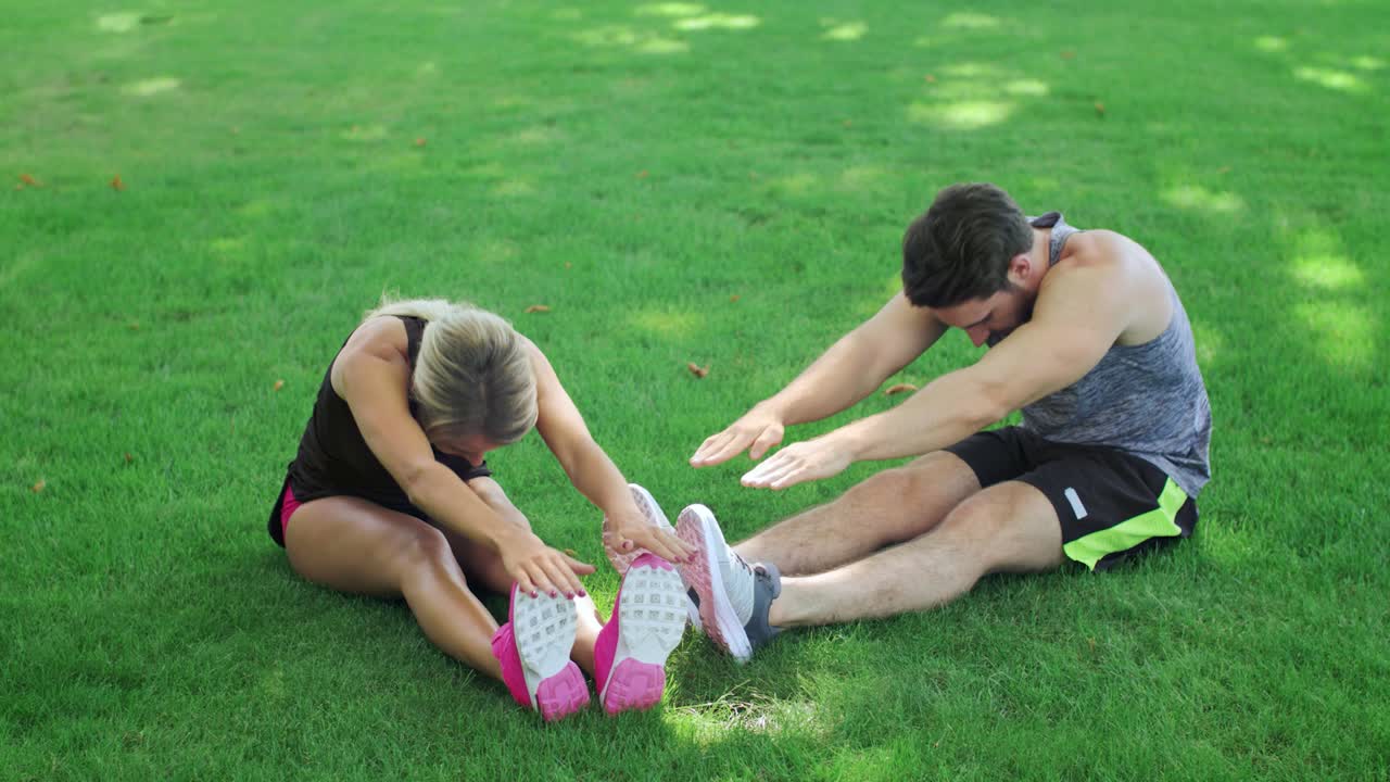 pareja joven entrenando ejercicios de estiramiento juntos en el parque de verano