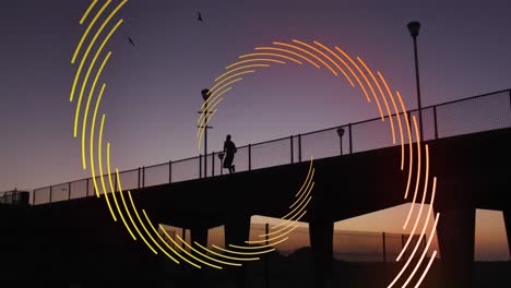Animation-of-orange-line-spiral-rotating-over-man-running-on-bridge-at-sunset-in-city