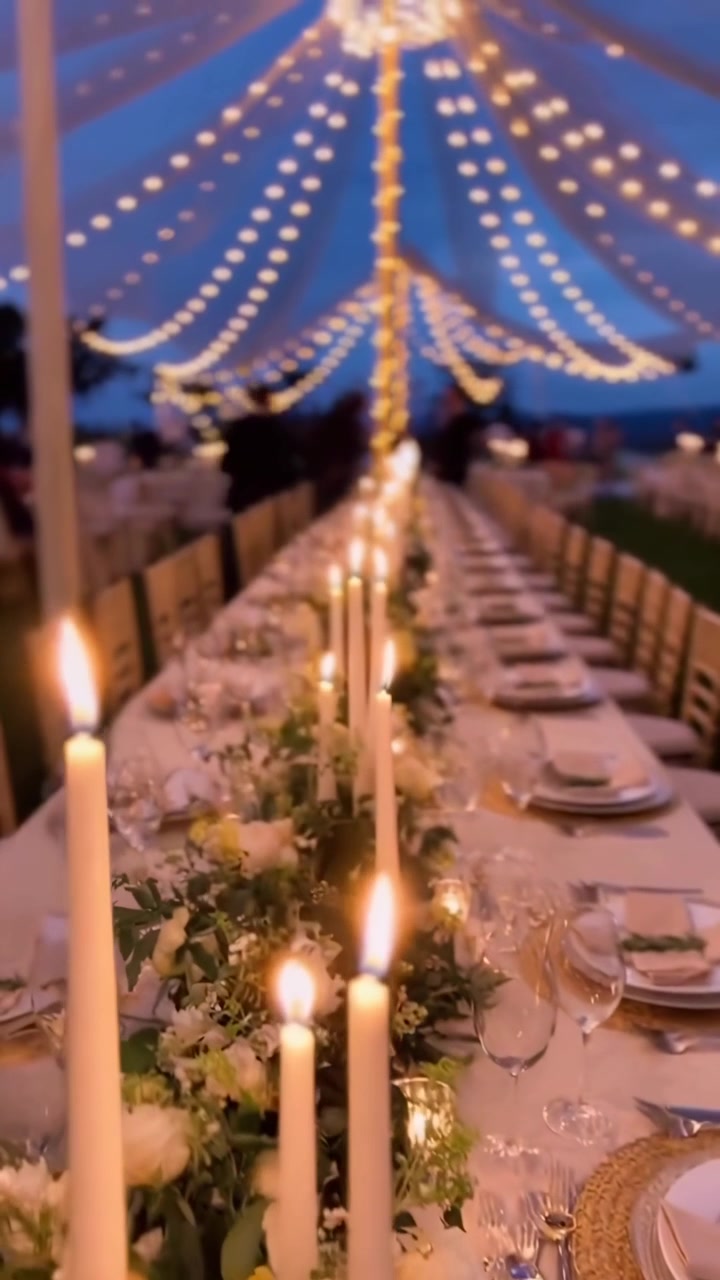 Allestimento lussuoso della tavola per un ricevimento di matrimonio con candele e lucine