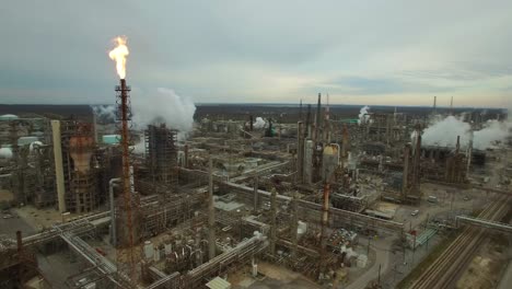 excellent aerial over huge industrial oil refinery with gas torch burning 1