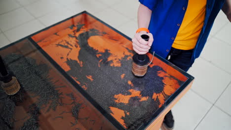 the boy play with iron powder in an entertainment and educational center. science museum