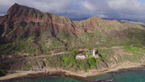 Drone-footage-starting-at-Diamond-Head-Lighthouse-on-the-island-of-Oahu-as-it-backs-away-to-reveal-Diamond-Head-Volcanic-rock-formation-in-the-background