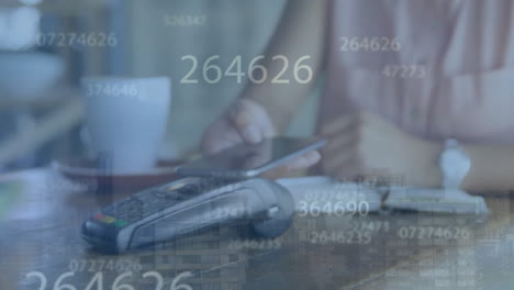 animación del procesamiento de datos financieros sobre una mujer biracial que paga con un teléfono inteligente