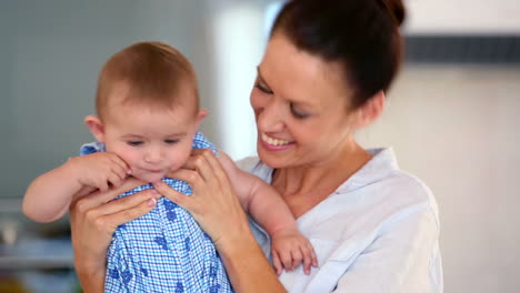 Pretty-mother-holding-baby-and-smiling-at-camera