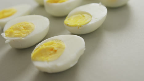 video of close up of halves of hard boiled eggs on grey background