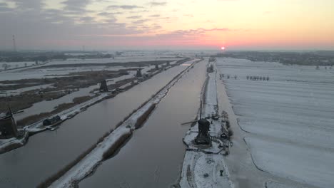 Muy-Por-Encima-De-Los-Molinos-De-Viento-De-Kinderdijk-Con-Tierra-Cubierta-De-Nieve-Al-Amanecer-Temprano