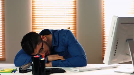 Male-graphic-designer-relaxing-while-working-on-computer