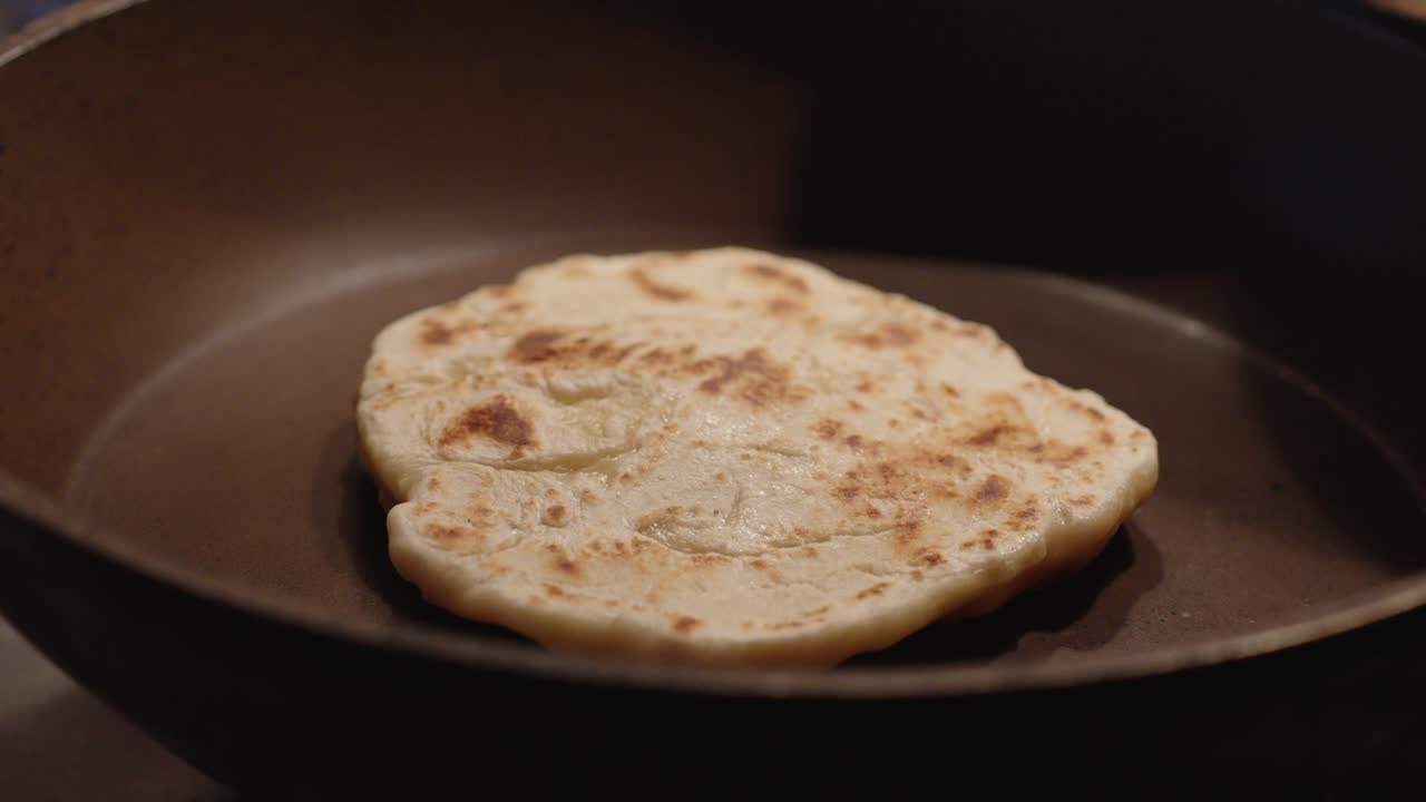 White flour flatbread baked in a pan. Homemade dough and dinner preparation
