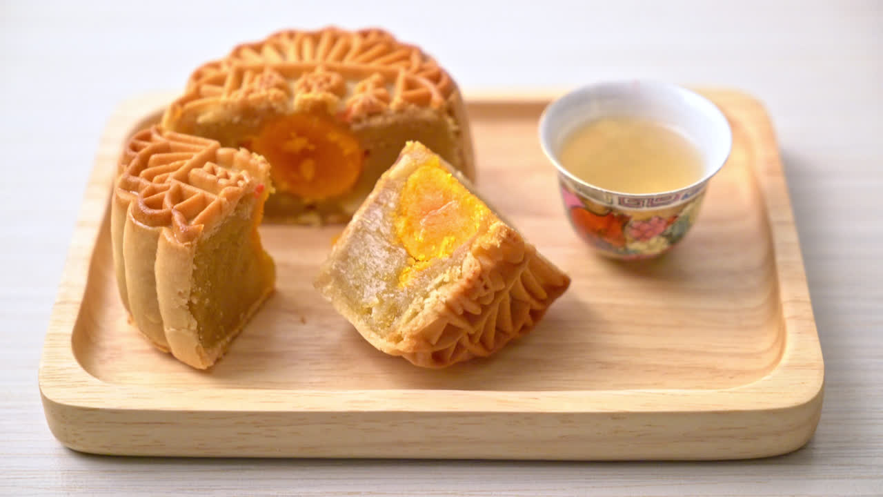 bolo de lua chinesa durian e sabor de gema de ovo com chá na placa de madeira