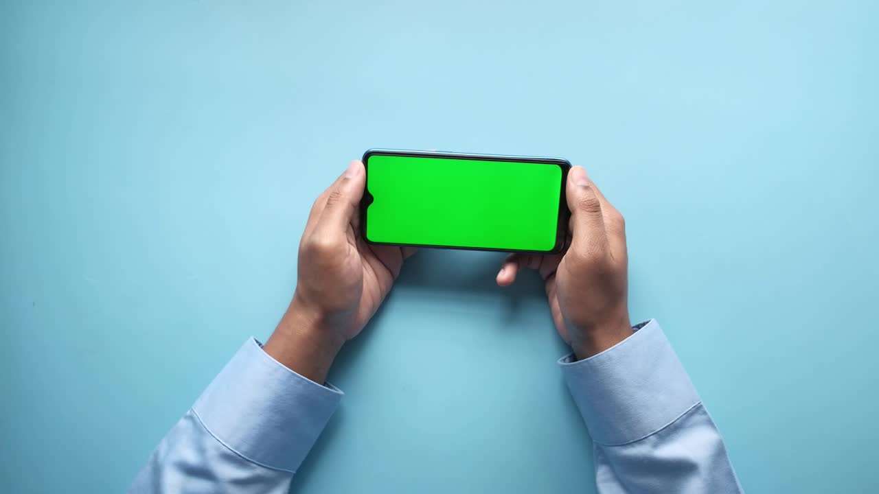 초록색 화면의 스마트폰을 들고 있는 사람