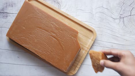 breaking a block of brown sugar candy