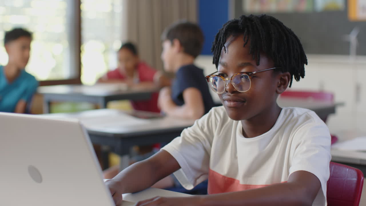 In school, student using laptop and listening attentively in classroom