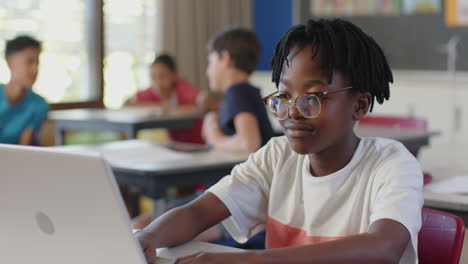 in school, student using laptop and listening attentively in classroom