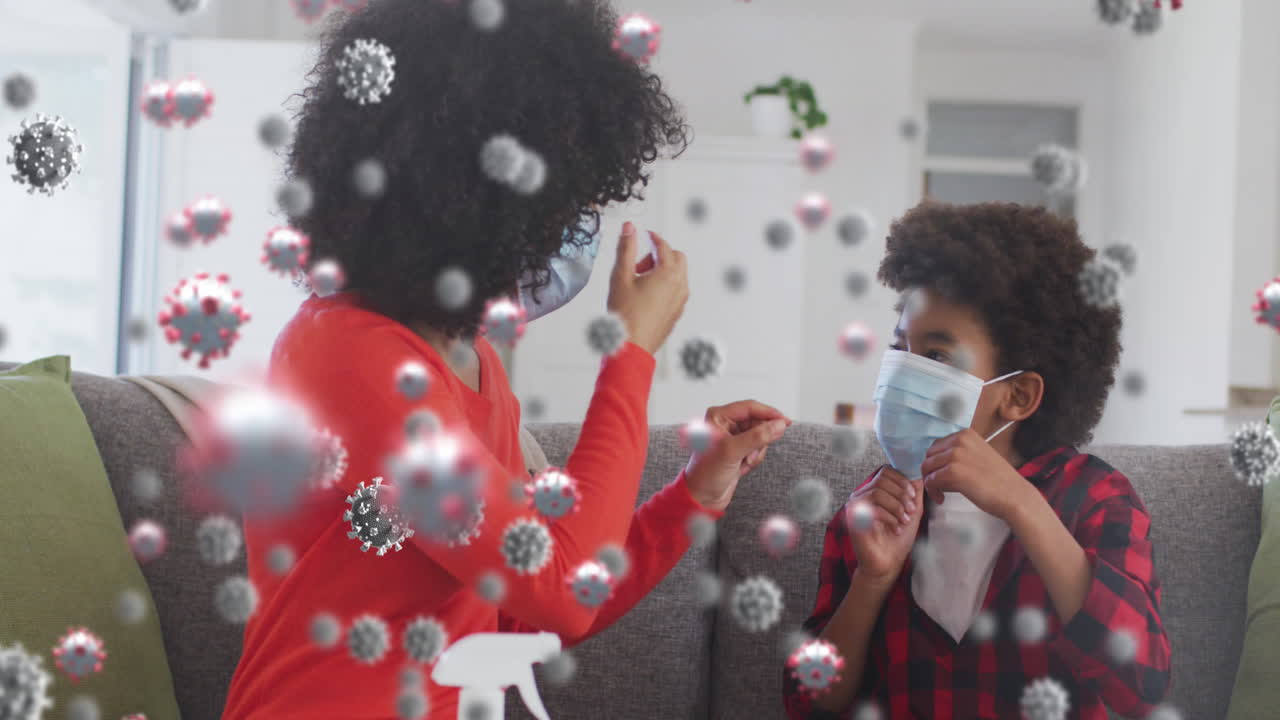 코로나 바이러스 세포의 애니메이션은 얼굴 마스크를 착용한 양색 어머니와 아들을 상징합니다.