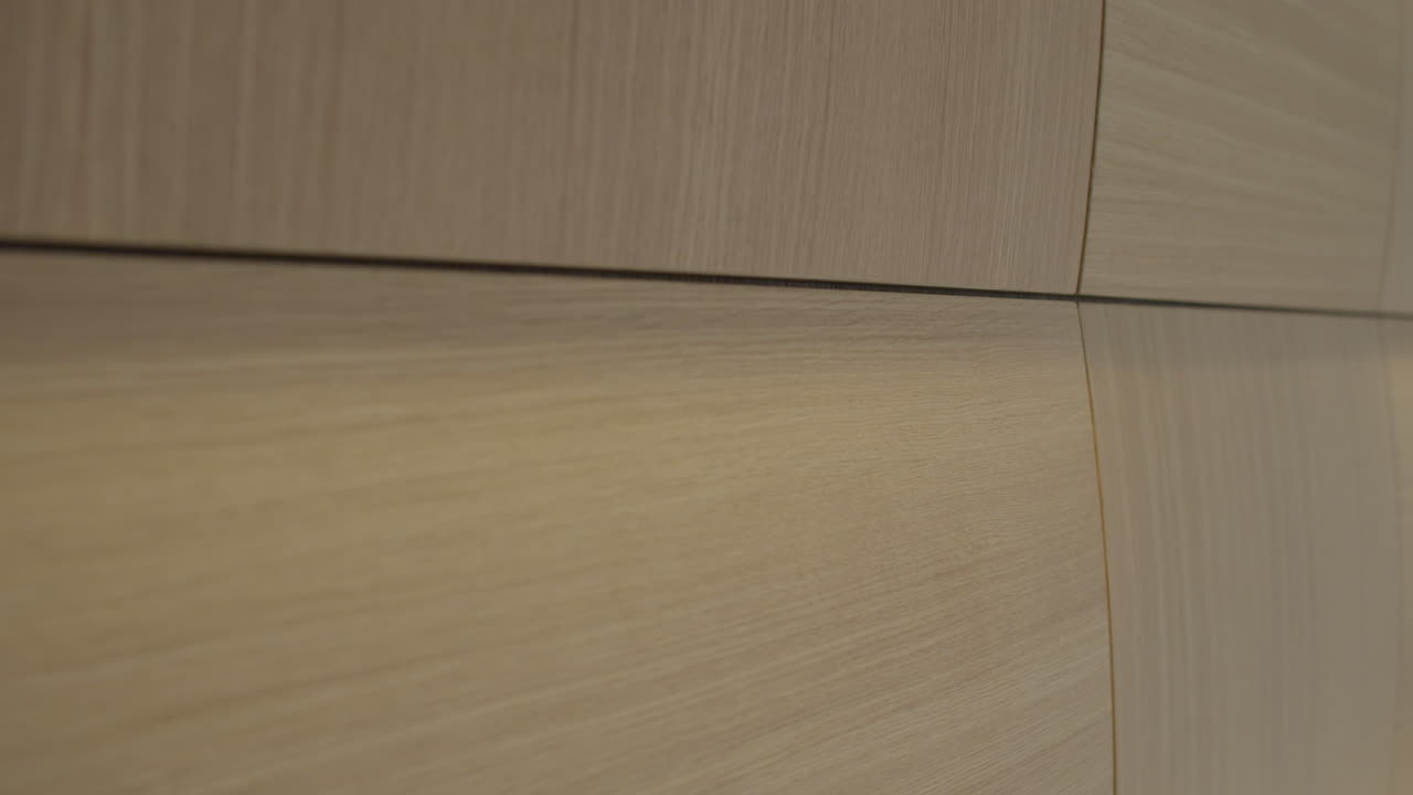 High quality video of a cozy bedroom with soft wall lights, warm wood paneling and clean white bedding creating a calm and inviting atmosphere