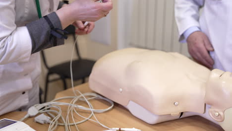 hands on cpr practice dummy. plastic dummy with connected life support sensors on hospital bed