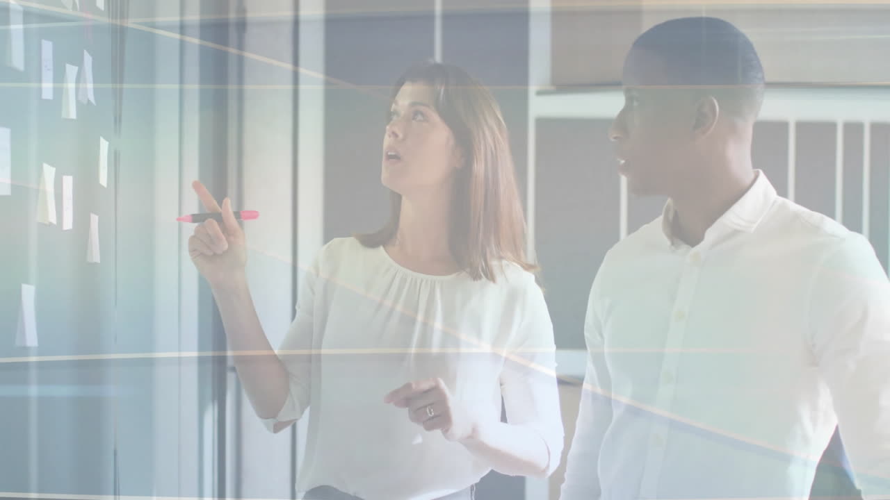 Colleagues pointing sticky notes on glass wall in business office, showing animated idea icons