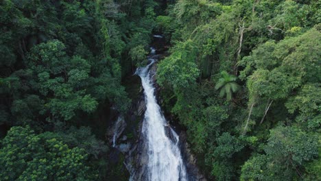 drone flying down in front a waterfall
