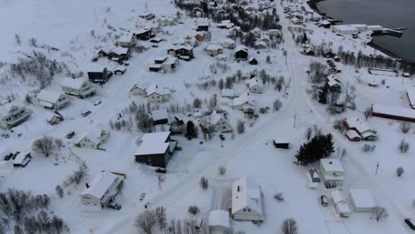 vista del avión no tripulado en el área de tromso en invierno volando sobre una pequeña ciudad con un paisaje lleno de nieve junto a un fiordo en noruega