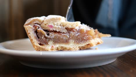 a close up of a delicious slice of apple pie on a white plate