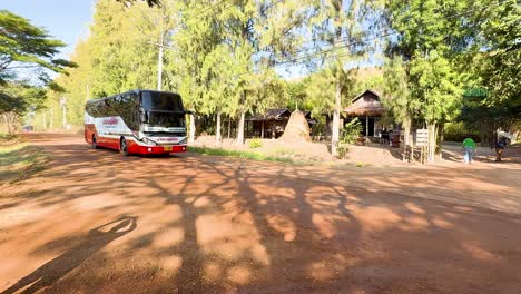 bus on a dirt road in a tropical setting