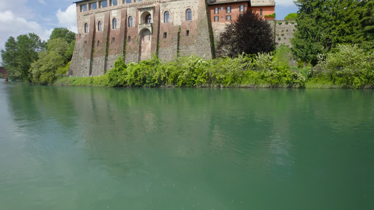 이탈리아 롬바르디아의 카사노 다다에 있는 석조 건물 옆 호수 위로 공중 촬영
