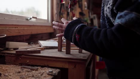 hombre usando un taladro de mano en la construcción de marcos de madera - de cerca