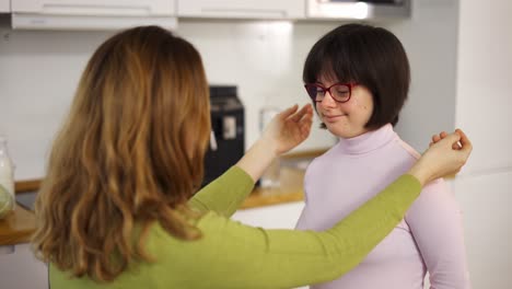 madre acaricia a su encantadora hija con síndrome de down