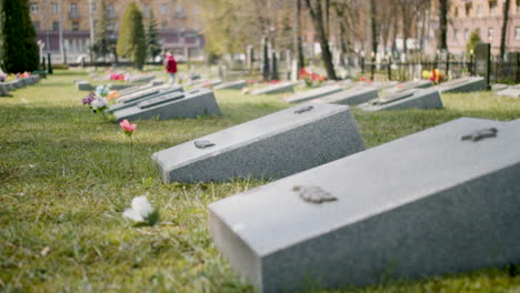 zoom in of a graveyard with tombstones in an urban area on a sunny day