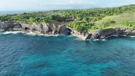 cave in a cliff with turquoise water - broken beach indonesia