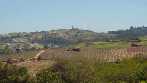 Vista-Lejana-De-Pequeñas-Granjas-Simples-En-Las-Colinas-De-Brasil,-Divididas-Por-Caminos-De-Tierra-Y-Caminos-Que-Conducen-A-Pequeñas-Casas-De-Agricultores-En-Medio-De-Los-Cultivos-En-Una-Tranquila-Mañana-De-Primavera