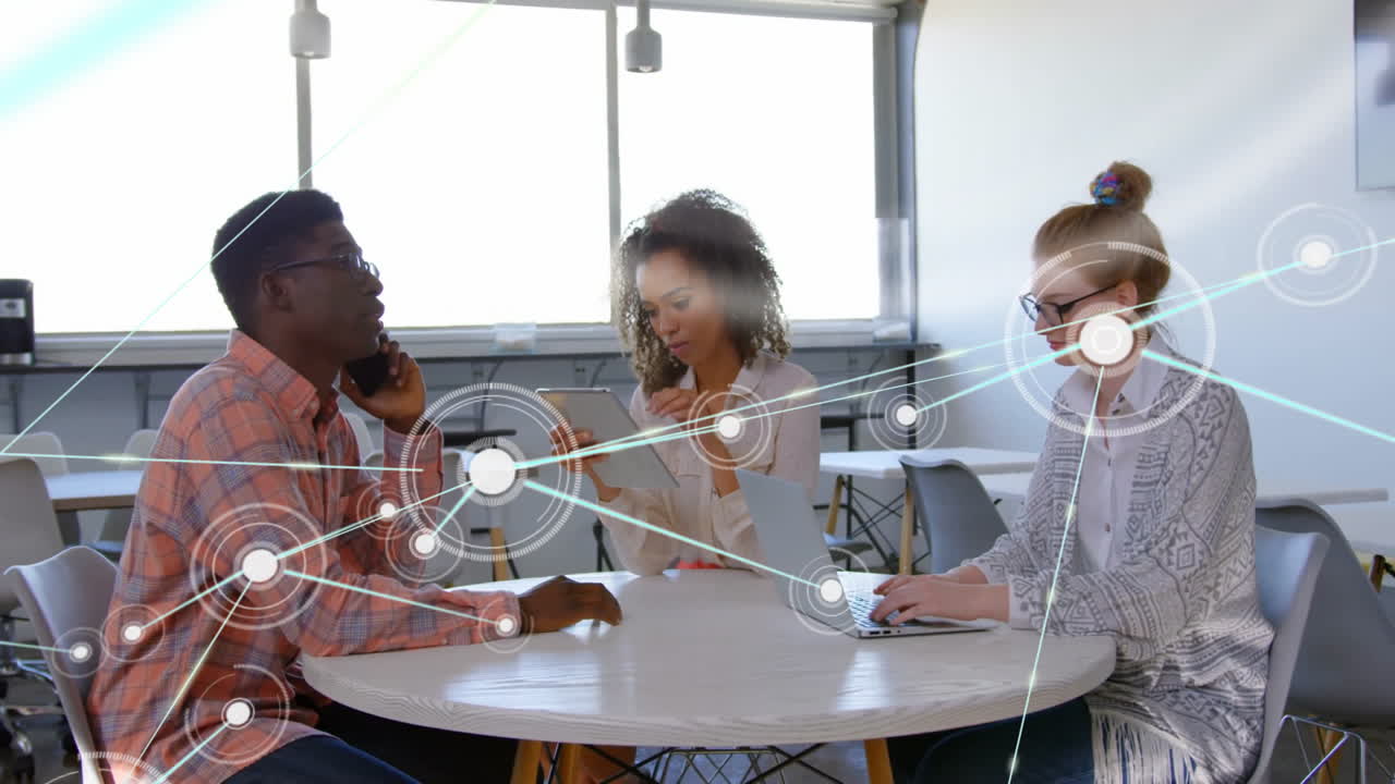 Animation of network of connections with icons over diverse colleagues discussing work in office