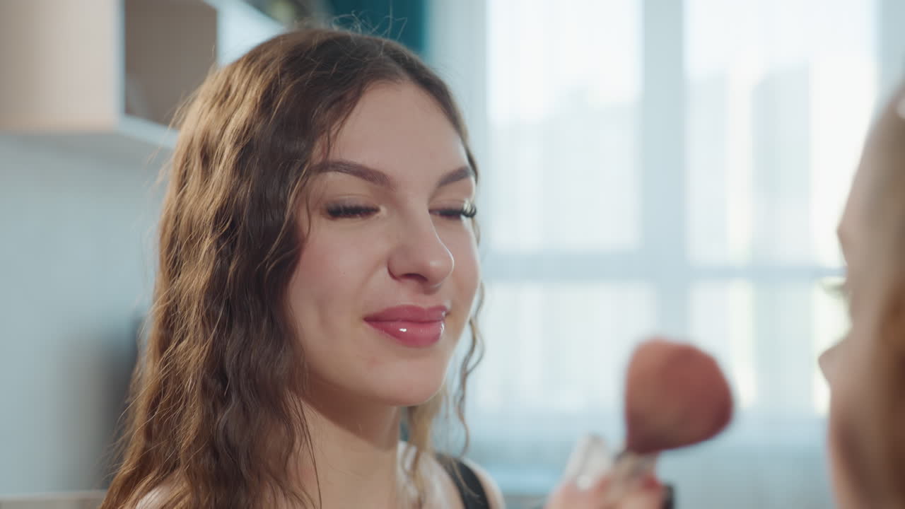 Woman Getting Makeup In Cozy Room, Caucasian Woman Receives Makeup From Friend In Relaxed Environment, Young Woman With Natural Hair Being Assisted By Friend In Tranquil Living Space