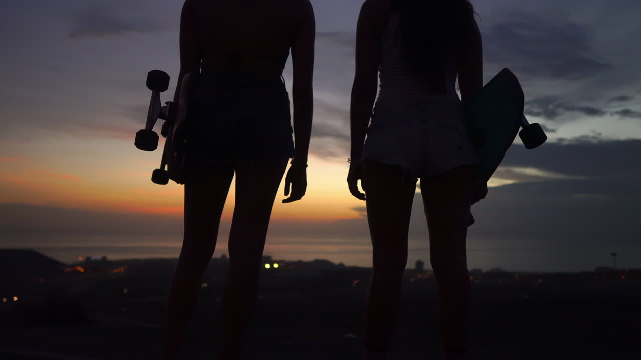 las amigas aprecian la pintoresca vista del cielo al atardecer después de su patinaje en la montaña