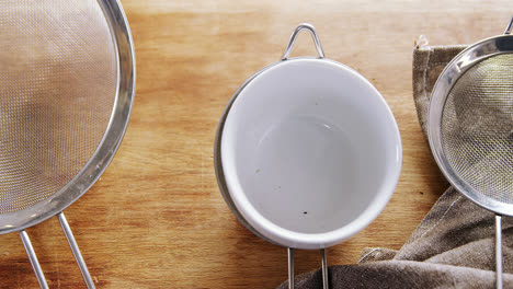 Strainer-and-bowl-on-wooden-table-4k