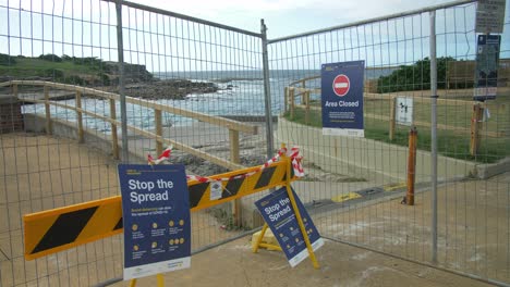 Valla-Metálica-Con-Carteles---Playa-Clovelly-Cerrada-Temporalmente-Debido-Al-Coronavirus---Sydney,-Nueva-Gales-Del-Sur,-Australia