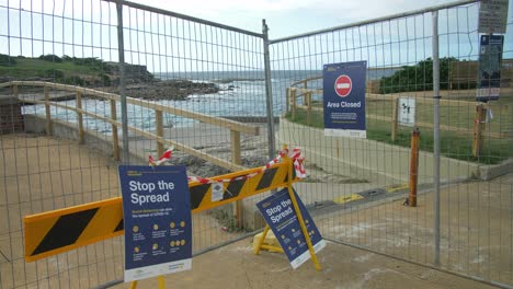 valla metálica con carteles - playa clovelly cerrada temporalmente debido al coronavirus - sydney, nueva gales del sur, australia