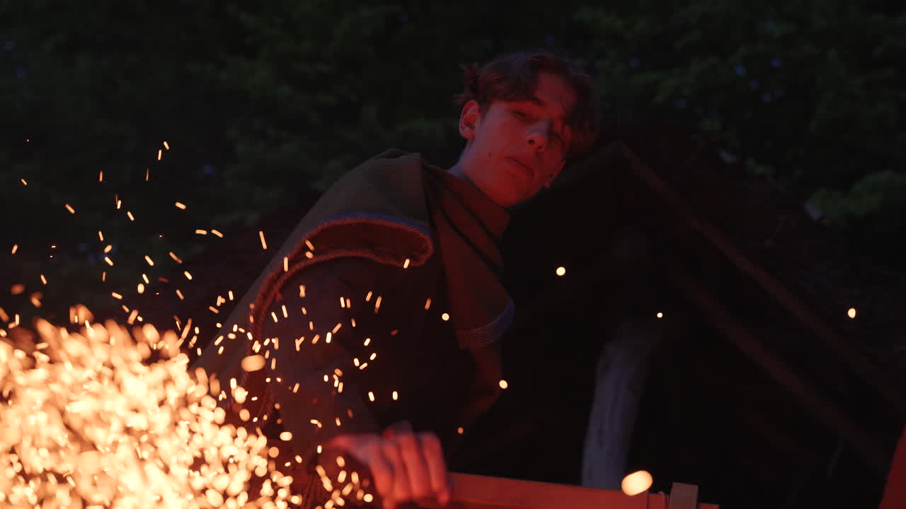 Medieval blacksmith at work at night