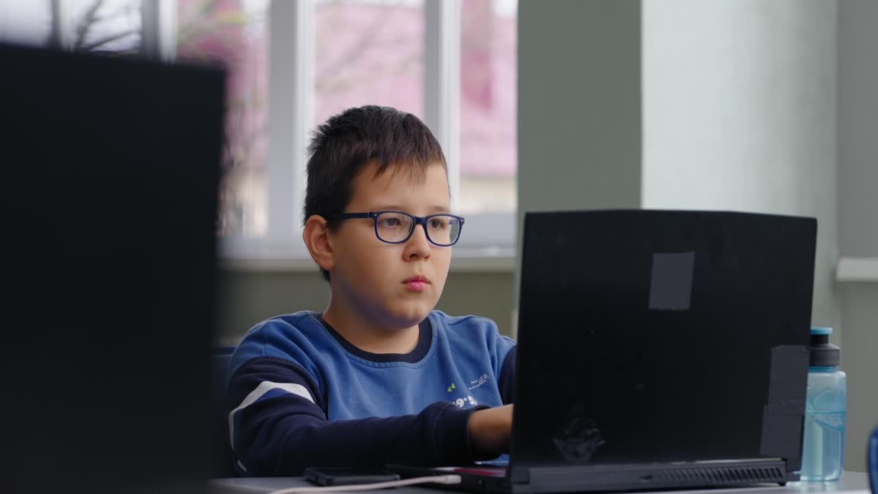 niño usando una computadora portátil en el aula