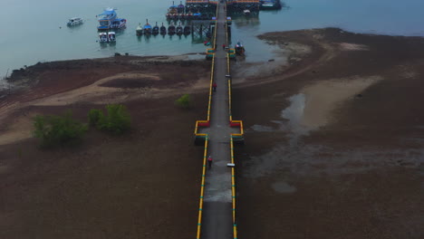 Walkway-and-floating-jetty-with-anchored-boats-on-Thailand-sea-coast