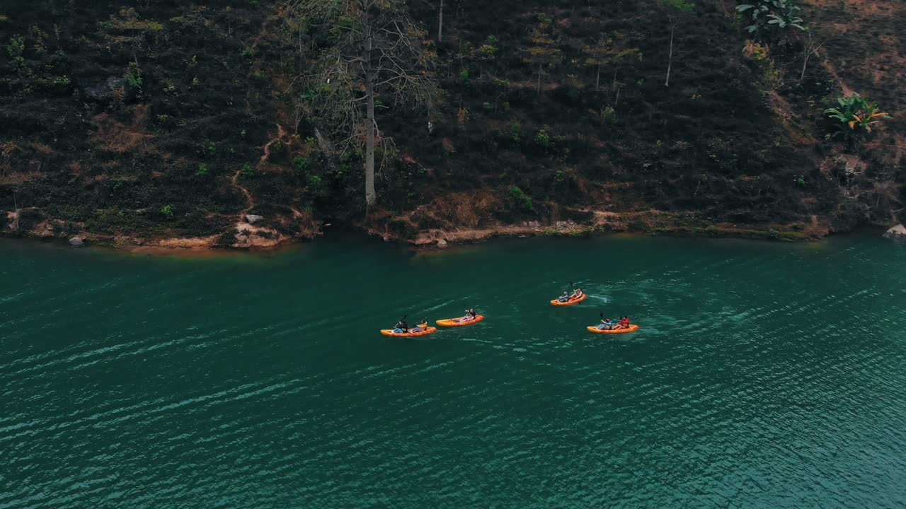 Aerial Over Group Of Kayakers On Nho Que River In Vietnam. Follow Shot