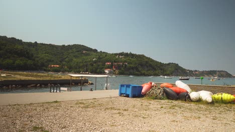 colorful buoys laying on the ground on the seashore