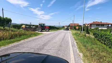 tractor cruzando la carretera en el pintoresco piamonte, italia