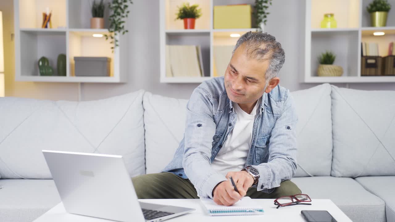 Hombre trabajando en su portátil con expresión feliz