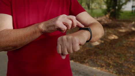 el corredor adulto comienza tocando la pantalla táctil en el reloj inteligente, rastreando la distancia, comprobando el pulso