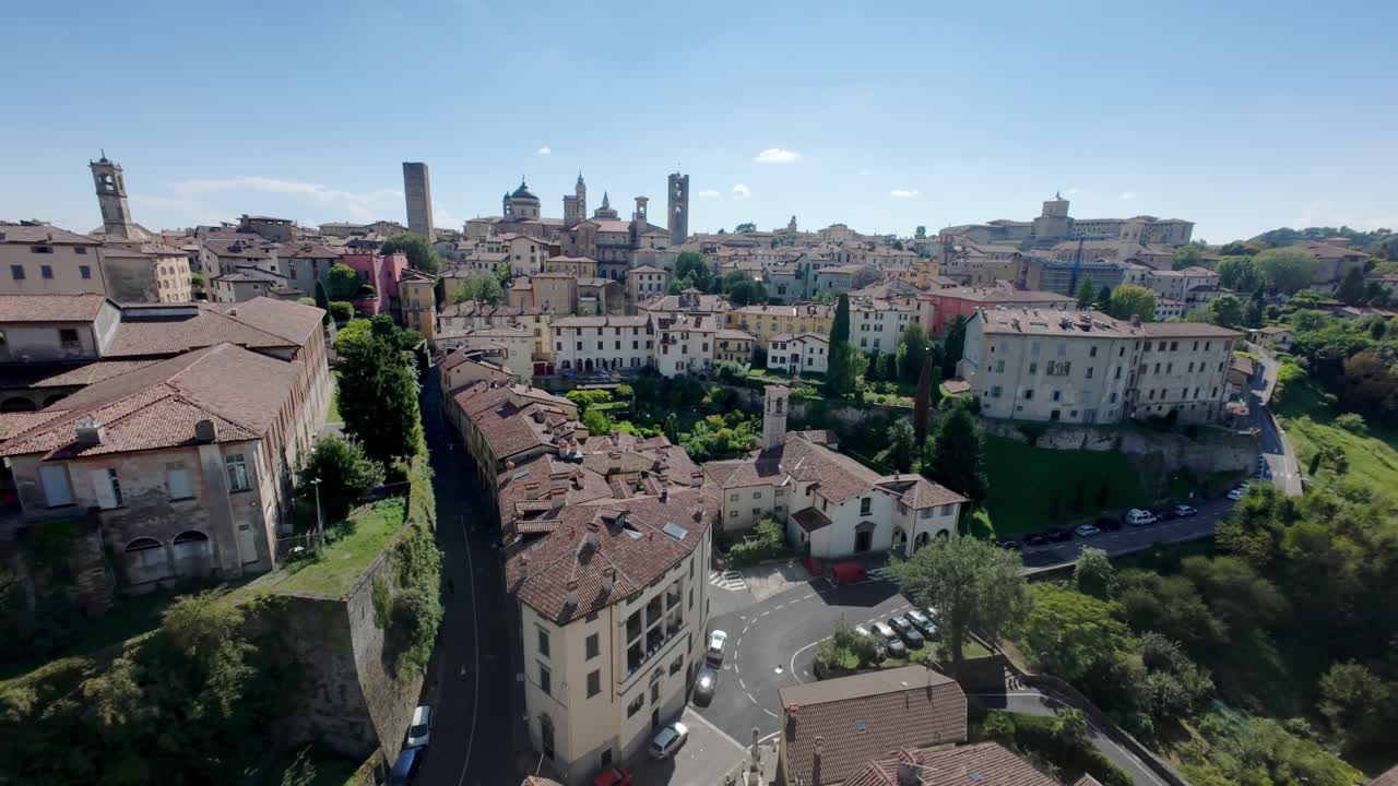 A flying shot over Bergamo alta ancient roofs. From green trees discovering the ancient town