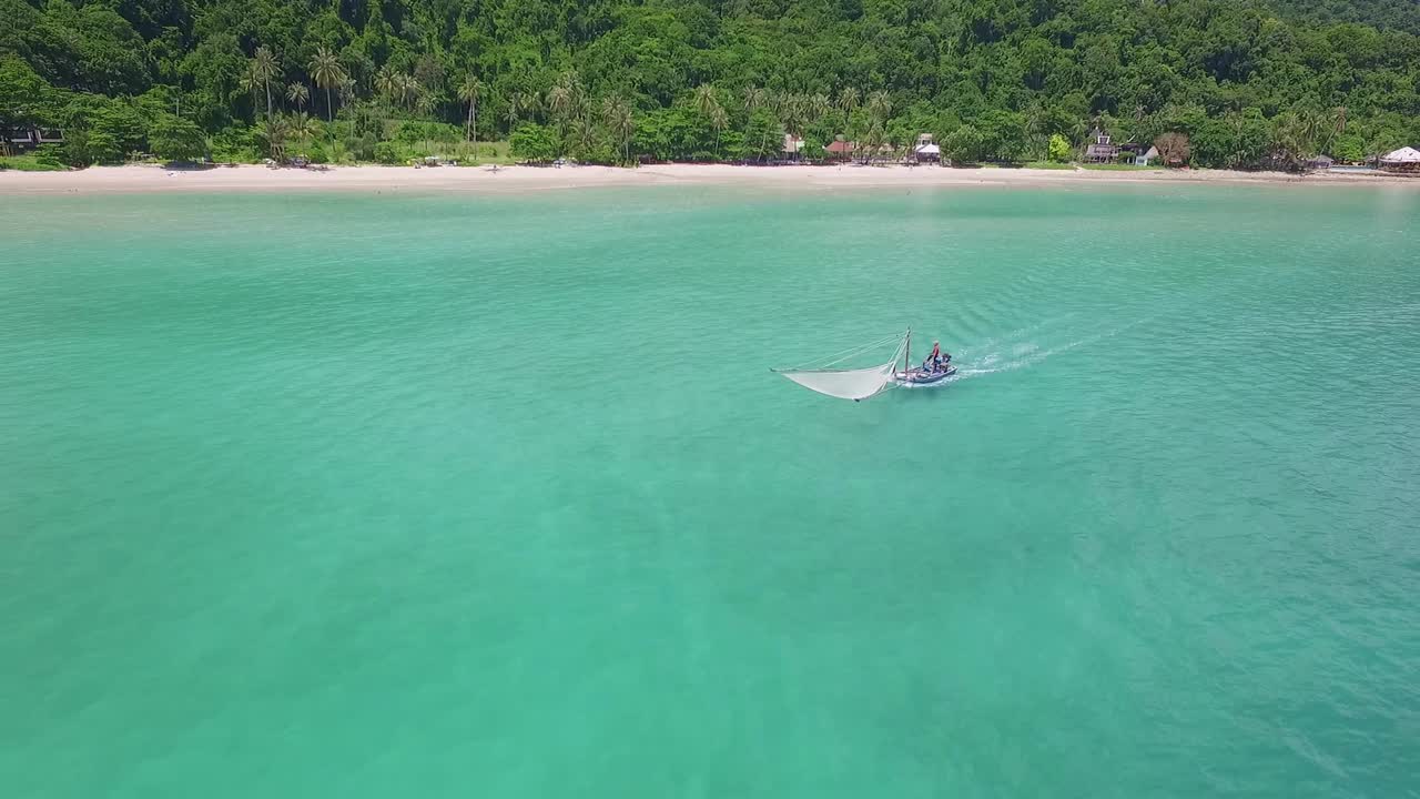 태국의 작은 나무 보트를 배경으로 해변을 배경으로 한 전통 새우 어부의 공중 뒤로 돌리 샷